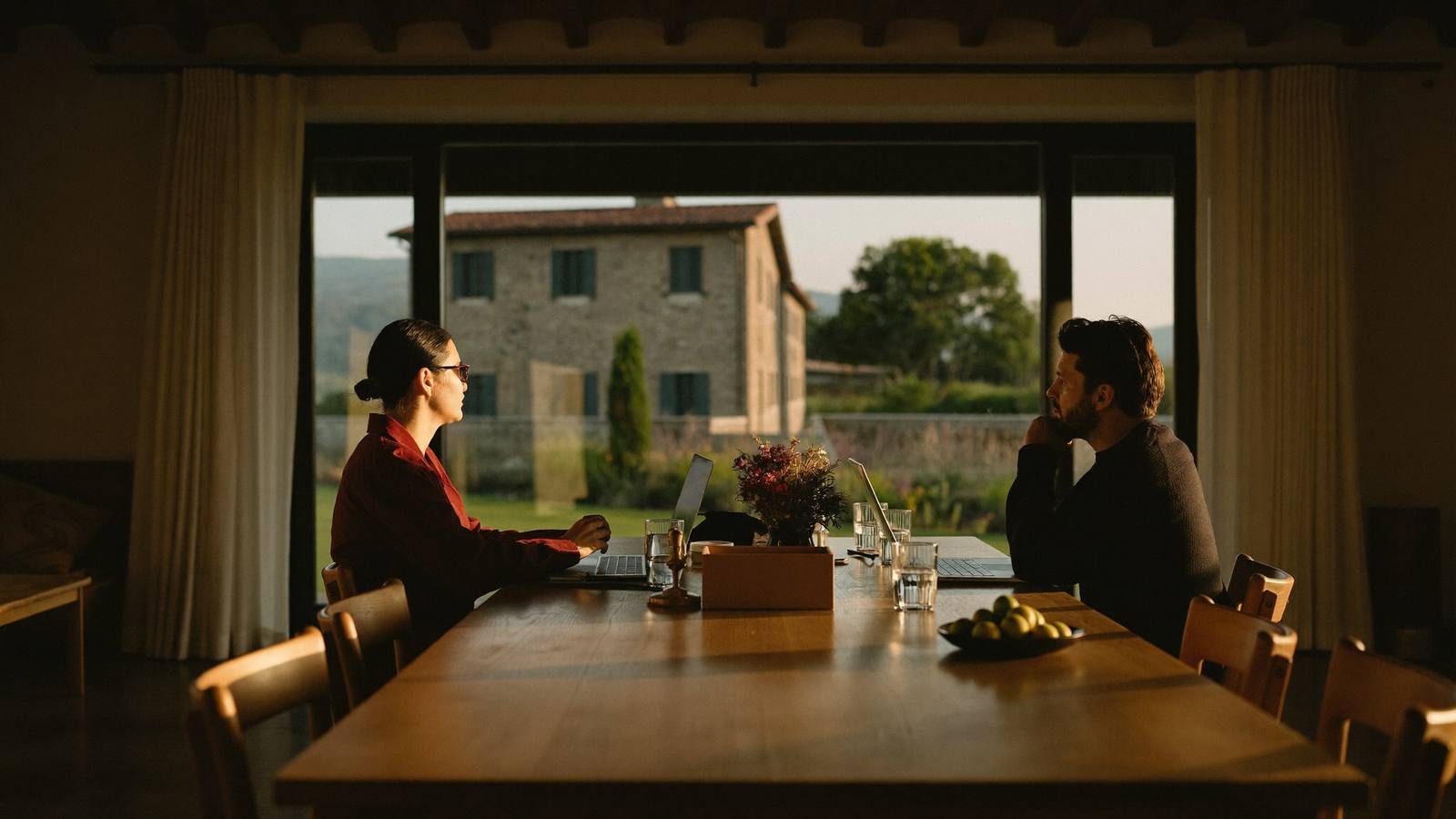 Two people in a business conversation at a table by a window